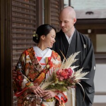 鎌倉・建長寺で春に撮影した和装前撮り 鎌倉・建長寺で色打掛を着用した新婦と紋付袴を着用した新郎がブーケを持ちほほ笑んでいるウェディングフォト