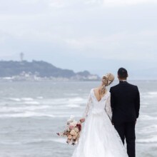 鎌倉・稲村ケ崎で夏に撮影した洋装前撮り 鎌倉・稲村ケ崎でウェディングドレスを着用した新婦とタキシードを着用した新郎の後ろ姿を写した洋装前撮り