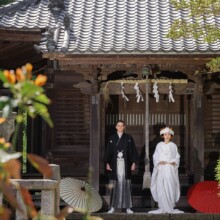 神社の前で白無垢と袴姿の新郎新婦が並ぶ和装ウェディングフォト