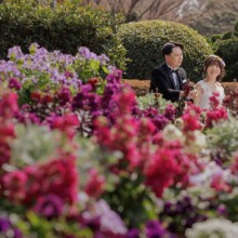 色とりどりの花々に囲まれながら微笑み合う新郎新婦