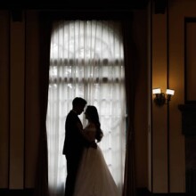 ベーリックホールのクラシックな窓辺で寄り添う新郎新婦のシルエット