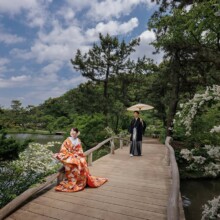 横浜・三溪園 2023.05.12 三溪園の木橋に座る花嫁と傘を持つ新郎、自然に包まれた前撮りショット