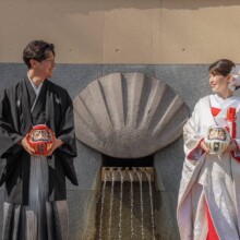 山手イタリア山庭園で達磨を持ち見つめ合う和装の新郎新婦の結婚式前撮り