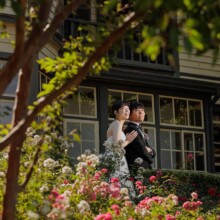 山手イタリア山庭園のバラ咲く洋館前で微笑み合う和装の新郎新婦
