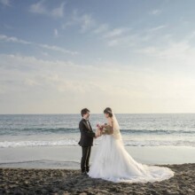 七里ヶ浜の波打ち際で向かい合う新郎新婦。夕暮れの海を背景に撮影した開放感あふれる鎌倉フォトウェディング。
