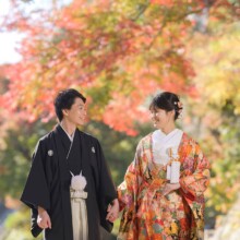 紅葉に彩られた建長寺で手をつなぎ見つめ合う新郎新婦。秋の自然を満喫する鎌倉和装前撮りのロケーション撮影。