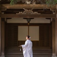 白無垢姿の新婦が和風建築を背に佇むウェディングフォト