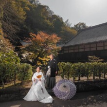 紅葉が始まる境内で和装の二人が寄り添う結婚式前撮り