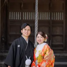 鎌倉・鎌倉本店の隣の神社で秋に撮影した和装前撮り 鎌倉・鎌倉本店で色打掛を着用した新婦と紋付袴を着用した新郎がほほ笑む和装前撮り