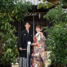 鎌倉・鎌倉本店の隣の神社で秋に撮影した和装前撮り 鎌倉・鎌倉本店の隣の神社で色打掛を着用した新婦と紋付袴を着用した新郎が笑顔で立って写る和装ウェディングフォト