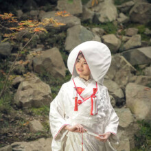 岩間に生えるもみじの枝を眺める和装の新婦