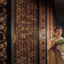 和柄の柵の間で、花を持って佇む和装の新婦