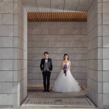高級感がある石造りの建物で並ぶ洋装の新郎新婦