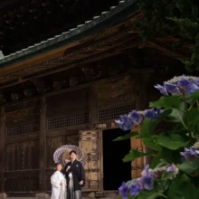 鎌倉・建長寺 2024.06.20 建長寺の仏殿と一面に咲く紫陽花を望む境内で、和傘を手に寄り添う白無垢姿の新婦と紋付袴姿の新郎。初夏の鎌倉で撮影した白無垢前撮り・鎌倉和装前撮りのロケーションフォトです。