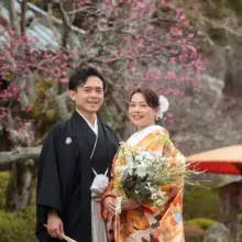 鎌倉・海蔵寺で冬に撮影した和装前撮り 鎌倉・海蔵寺で色打掛を着用した新婦と紋付袴を着用した新郎がこちらを見てほほ笑む和装前撮り