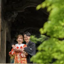 鎌倉・妙本寺 2023.05.08 妙本寺の歴史ある木造建築を背景に、抱き合って笑顔を見せる色打掛姿の新婦と紋付袴姿の新郎。初夏の鎌倉で撮影した色打掛前撮り・鎌倉和装前撮りのロケーションフォトです。