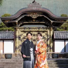 鎌倉・建長寺で秋に撮影した和装前撮り 鎌倉・建長寺で色打掛を着用した新婦と紋付袴を着用した新郎が唐門の前で写る和装前撮り