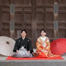 鎌倉・建長寺で秋に撮影した和装前撮り 鎌倉・建長寺で色打掛を着用した新婦と紋付袴を着用した新郎が正座をしている和装ウェディングフォト