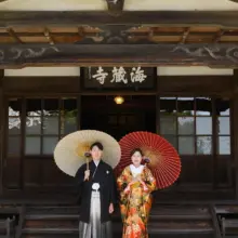 鎌倉・海蔵寺で春に撮影した和装前撮り 鎌倉・海蔵寺で色打掛を着用した新婦と紋付き袴を着用した新郎が番傘を持ち立っている和装ウェディングフォト