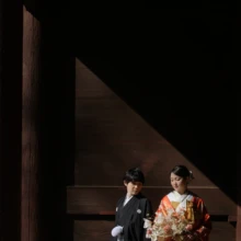 妙本寺での1カット。朱色の山門の壁で光に優しく包まれる紋付き袴の新郎と色打掛の新婦