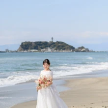 鎌倉・七里ガ浜で春に撮影した洋装前撮り 鎌倉・七里ガ浜でウェディングドレスを着用した新婦がブーケを持って写る洋装ソロショット