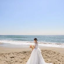 鎌倉・七里ガ浜で春に撮影した洋装前撮り 鎌倉・七里ガ浜でウェディングドレスを着用した新婦の後ろ姿を写した洋装ウェブサイトソロショット