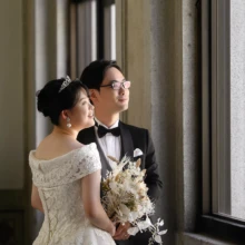 横浜・開港記念会館で夏に撮影した洋装前撮り 横浜・開港記念会館でウェディングドレスを着用した新婦がとタキシードを着用した新郎が遠くを見つめる洋装ウェディングフォト