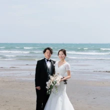 鎌倉・由比ガ浜で春に撮影した洋装前撮り 鎌倉・由比ガ浜でウェディングドレスを着用した新婦とタキシードを着用した新郎がブーケを持って写る洋装前撮り