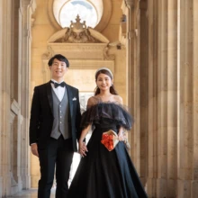 パリで夏に撮影した洋装前撮り パリで黒のウェディングドレスを着用した新婦とタキシードを着用した新郎がブーケを持ち手を繋いで写る洋装前撮り