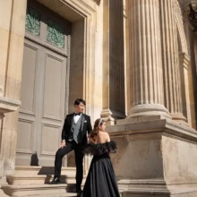 パリで夏に撮影した洋装前撮り パリで黒のウェディングドレスを着用した新婦とタキシードを着用した新郎が階段で写る洋装前撮り