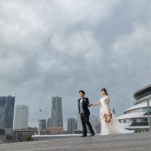 横浜・大桟橋で春に撮影した洋装前撮り 横浜・大桟橋でウェディングドレスを着用した新婦とタキシードを着用した新郎が手を取って歩く洋装ウェディングフォト
