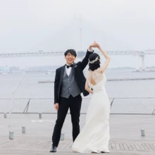 横浜・大桟橋で春に撮影した洋装前撮り 横浜・大桟橋でウェディングドレスを着用した新婦とタキシードを着用した新郎が手を取って踊る洋装ウェディングフォト