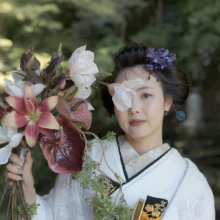 妙本寺の緑を背景に、ブーケを手にした白無垢姿の花嫁。|縁グラフィの姉妹ブランドLuca 鎌倉・妙本寺で白無垢姿の花嫁をブーケとともに撮影した和装前撮り