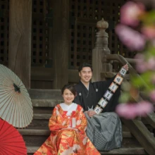 鎌倉 和装 K様・K様 2020.03.31 妙本寺の階段に腰掛け、和傘と「結婚しました」の小物を添えた色打掛姿の新婦と黒紋付袴姿の新郎