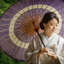 鎌倉 和装 S様・S様 2021.04.02 妙本寺の新緑を背景に、紫の和傘を差し、白無垢姿で手元を見つめる花嫁の鎌倉和装前撮り