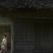 成人式撮影 H様 2021.05.09 檑亭の茅葺き屋根の古民家で、淡い色の振袖を着た成人女性が縁側に腰掛ける成人式ロケーション撮影
