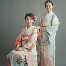 成人式撮影 H様 2021.05.09 椅子に座る淡い振袖姿の成人女性と、その後ろに立つ薄緑とピンクの着物姿の妹による姉妹の記念撮影