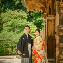 鎌倉 和装 M様・Y様 2021.06.01 建長寺の大きな木造建築と深い軒を背景に、朱赤の色打掛の新婦と黒紋付袴の新郎が並ぶ鎌倉和装前撮り