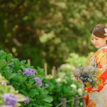 鎌倉 和装 M様・Y様 2021.06.01 紫陽花が咲く建長寺の境内で、青紫のブーケを持ち朱赤の色打掛姿で横を向く新婦の鎌倉和装前撮り