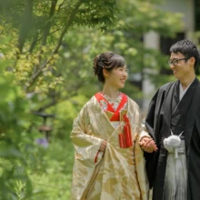 鎌倉 和装 K様・Y様 2021.06.11 新緑に囲まれた檑亭の庭園で、手を取り合いながら笑顔を交わす色打掛の新婦と黒紋付袴の新郎