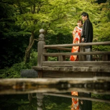 鎌倉 和装 T様・T様 2021.06.21 妙本寺の木造建築の高欄沿いで寄り添う色打掛の新婦と黒紋付袴の新郎を、水面への映り込みとともに捉えた鎌倉和装前撮り