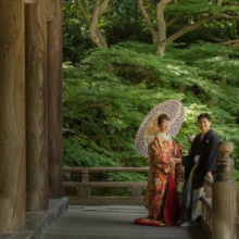 鎌倉 和装 M様・N様 2021.06.28 鎌倉・妙本寺の回廊で、華やかな色打掛姿の新婦が和傘を差し、黒紋付袴の新郎と並ぶ鎌倉和装前撮り