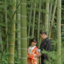 鎌倉 和装洋装 S様・S様 2021.06.25 英勝寺の竹林に囲まれ、朱赤の色打掛の新婦と黒紋付袴の新郎が寄り添って手元を見る和装前撮り