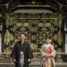 鎌倉 和洋装 K様・M様 2021.09.24 建長寺の唐門を背景に、正面を向いてほほ笑む色打掛の新婦と黒紋付袴の新郎の鎌倉フォトウェディング
