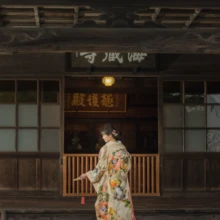 鎌倉 和装 S様・A様 2021.11.21 海蔵寺の本堂前で、赤い裾の華やかな色打掛をまとって横向きに立つ新婦の色打掛前撮り