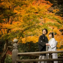 鎌倉 和装 A様・Y様 2021.12.07 鮮やかな紅葉が広がる妙本寺の橋で、寄り添って木々を見上げる白無垢の新婦と黒紋付袴の新郎