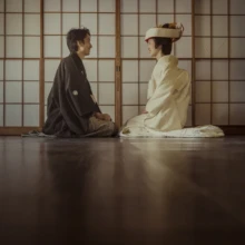 鎌倉 和装 T様・M様 2021.12.20 障子から光が入る古民家の和室で、正座して向かい合う黒紋付袴の新郎と白無垢に角隠し姿の新婦