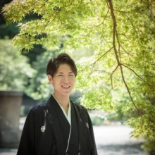 鎌倉 和洋装 K様・K様 2021.05.24 妙本寺の新緑から差し込む光を受け、黒紋付袴姿で笑顔を見せる新郎の鎌倉和装前撮りソロカット