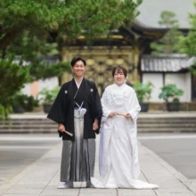 鎌倉 和装 B様・A様 2025.07.12 建長寺の松と歴史的な建物を背景に、白無垢の新婦と黒紋付袴の新郎が正面を向いて並ぶ全身構図
