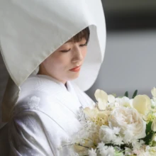鎌倉 和装 B様・A様 2025.07.12 綿帽子と白無垢をまとい、白や淡い緑のブーケを胸元に抱えて静かに目を伏せる新婦の上半身